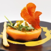 A cantaloupe and burrata salad is beautifully presented on a plate