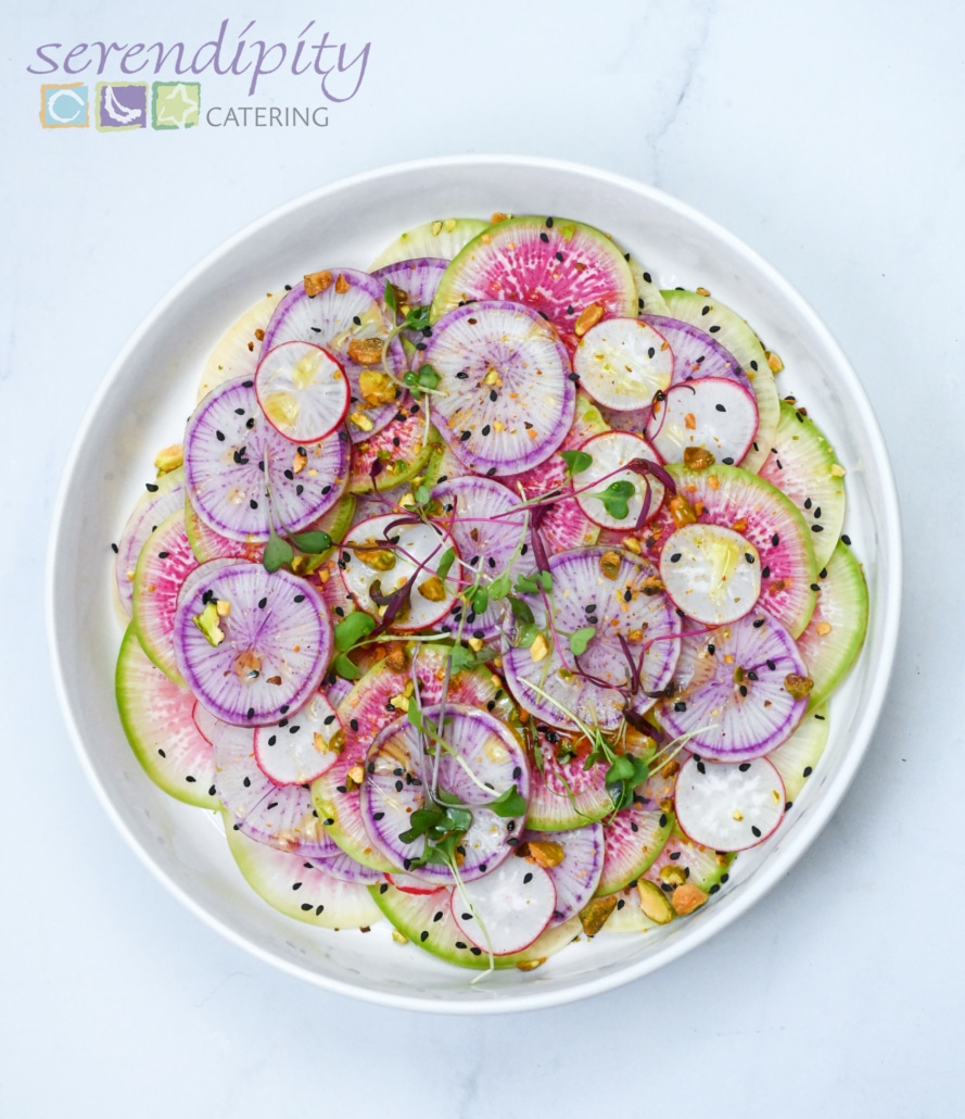 A bright radish salad is displayed in a white bowl