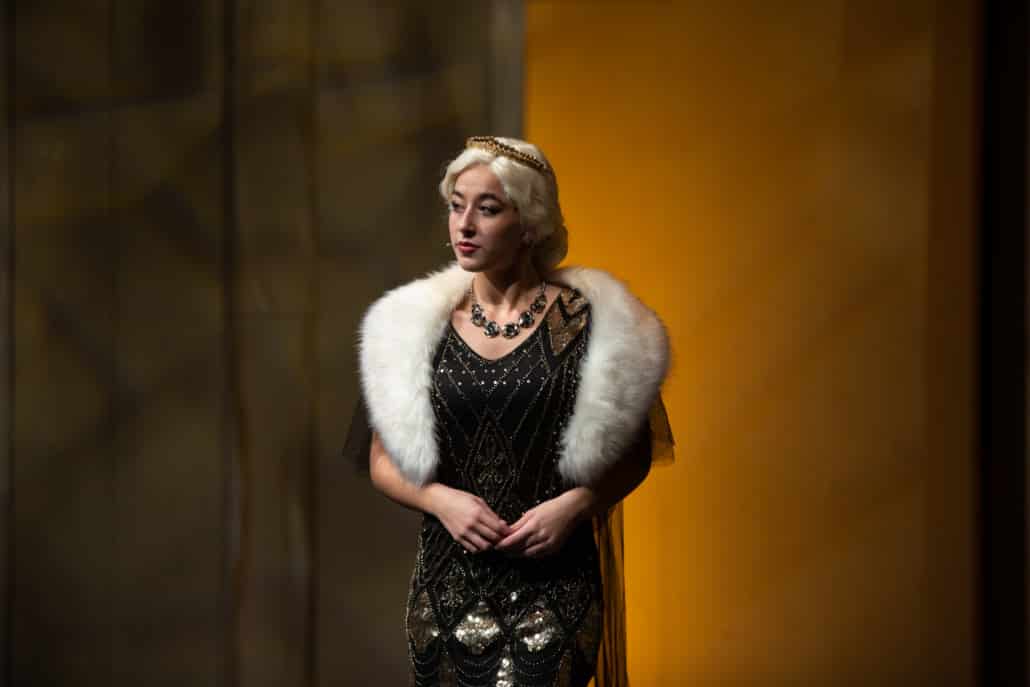 Ella Plourde in Anastasia wearing a glamorous gown with fur shawl