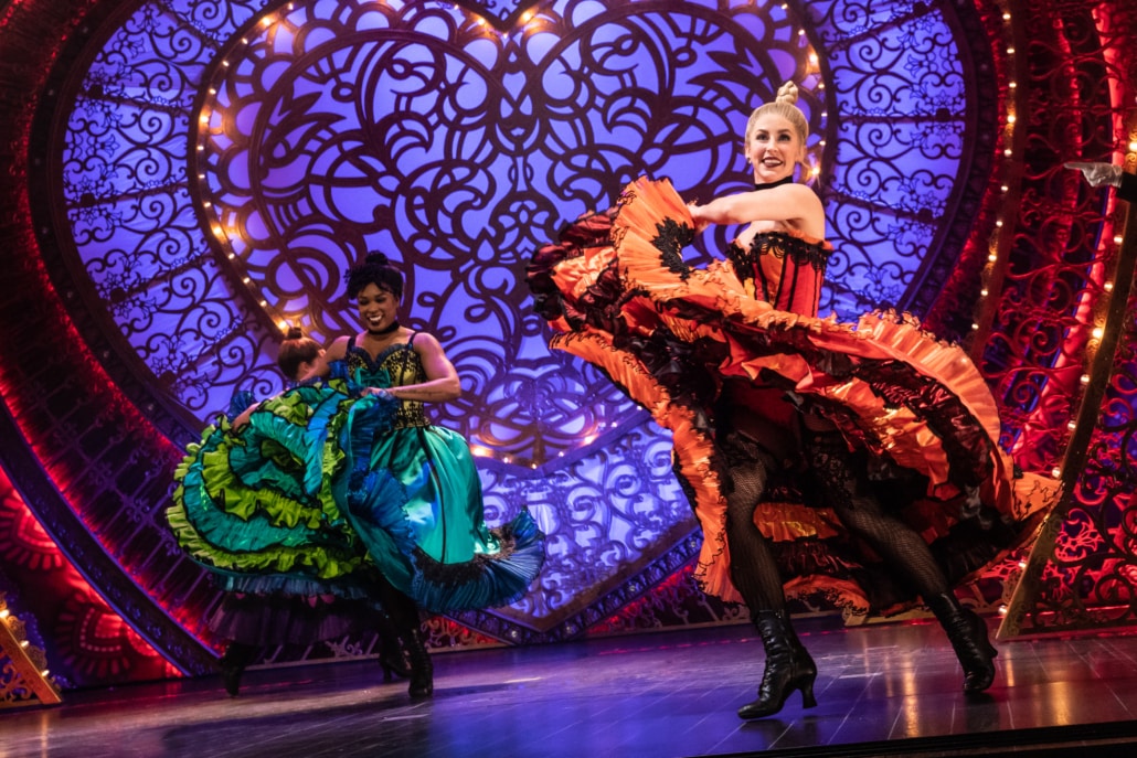 Two dancers in Moulin Rouge! The Musical swish their skirts in a cancan