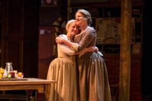 Two women embrace onstage in Book of Will