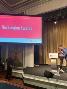 Jeff Hovorka hugs Laura Matalon as he walks onstage to receive the award