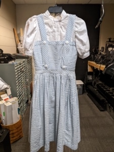 Dorothy's pinafore hangs in the costume shop