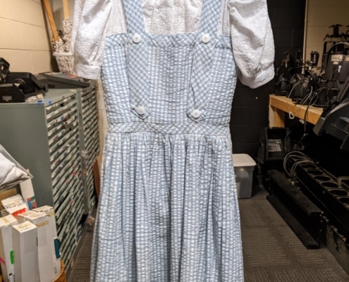 Dorothy's pinafore hangs in the costume shop