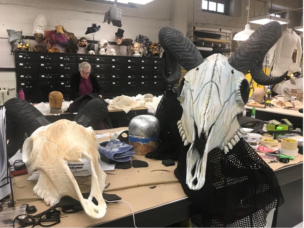 A prop skull is shown on a cluttered table