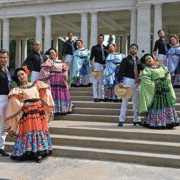 A group of dancers pose in colorful costumes