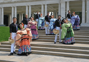 A group of dancers pose in colorful costumes