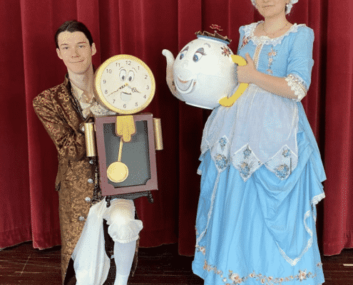 Students dressed as Cogsworth and Mrs. Potts pose for a photo