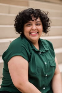 A headshot of Jess Martinez wearing a green shirt