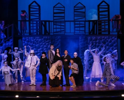 The cast of The Addams Family poses onstage