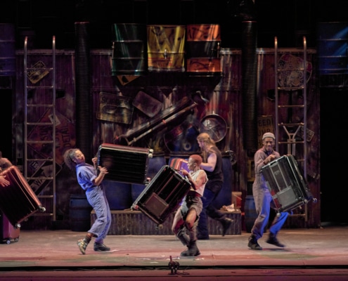 The cast of STOMP plays musical instruments onstage