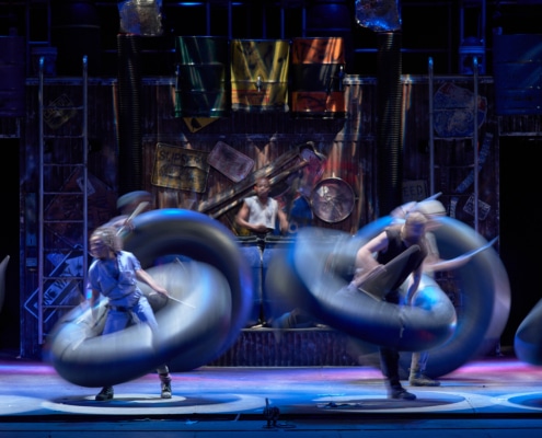 The cast of STOMP dance with inner tubes