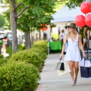 A fashionable woman walks down a sidewalk