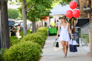 A fashionable woman walks down a sidewalk