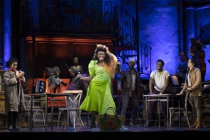 A woman dances center stage while others look on in Hadestown