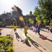 A group of people do yoga on a pavillion