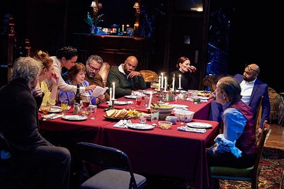 A group of people sit at a formal dinner table