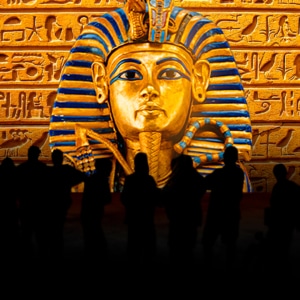 Shadows of people stand in front of a large rendering of King Tut's tomb