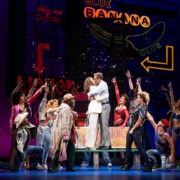 Vivian and Edward embrace surrounded by people in Pretty Woman: The Musical