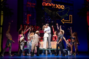 Vivian and Edward embrace surrounded by people in Pretty Woman: The Musical