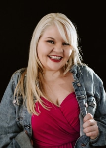 A young woman with blonde hair smiles for a photo