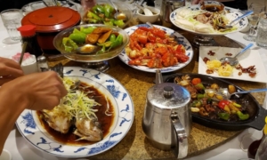 A table filled with Chinese food on large plates