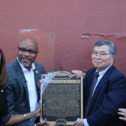 A group of people stand with a plaque