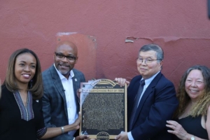 A group of people stand with a plaque