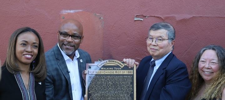 A group of people stand with a plaque