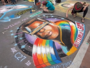 A chalk painting of a man surrounded by a rainbow