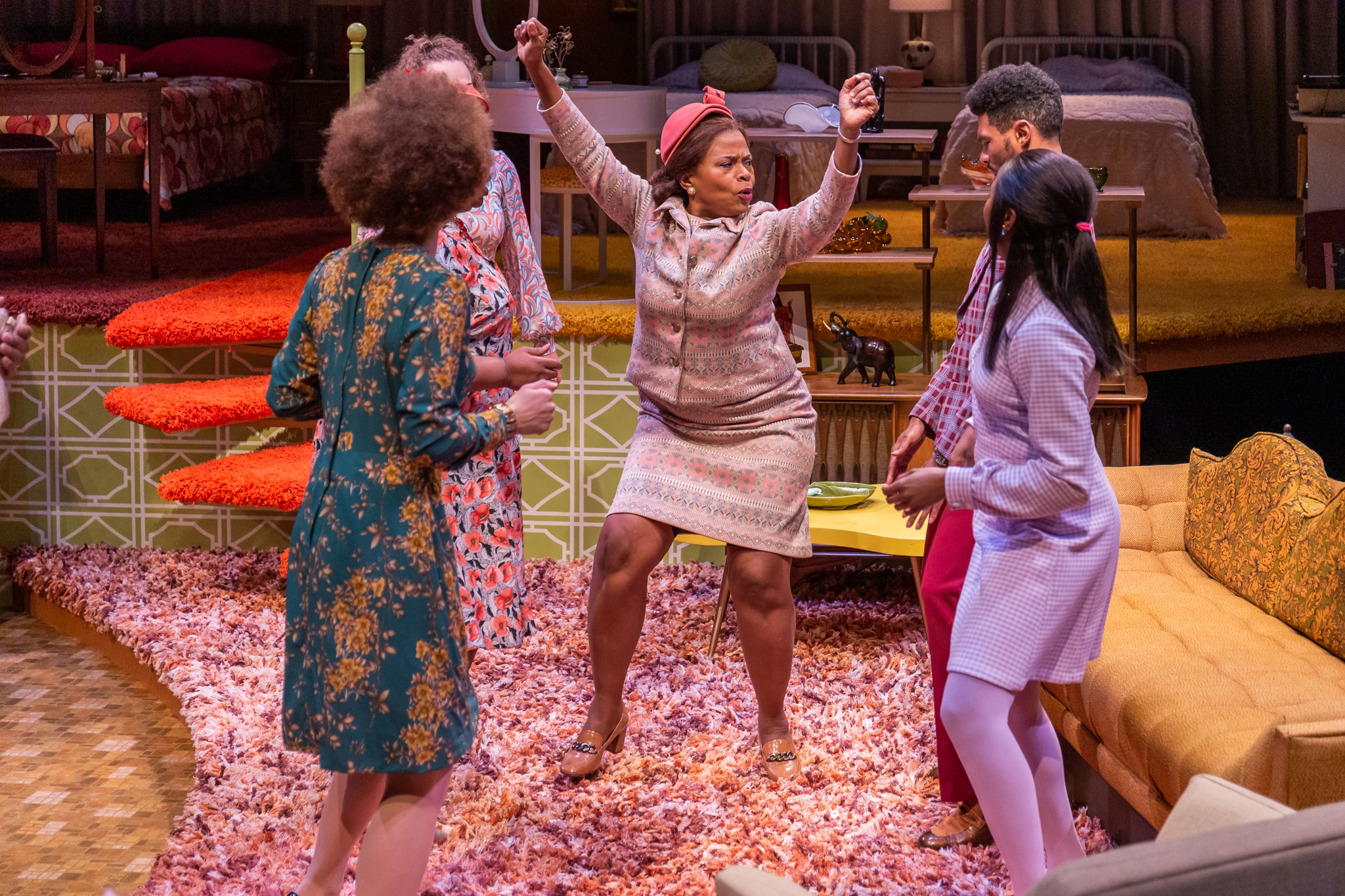 A woman surrounded by family strikes a pose as she dances in In the Upper Room.