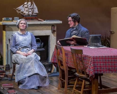 A man and woman are seated surrounded by books in You Lost Me.