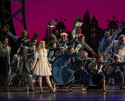 The cast of Wicked dances onstage with Glinda