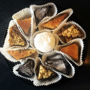 Greek pastries wrapped in paper placed in a circle