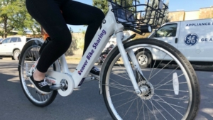 A person sits on a white ebike