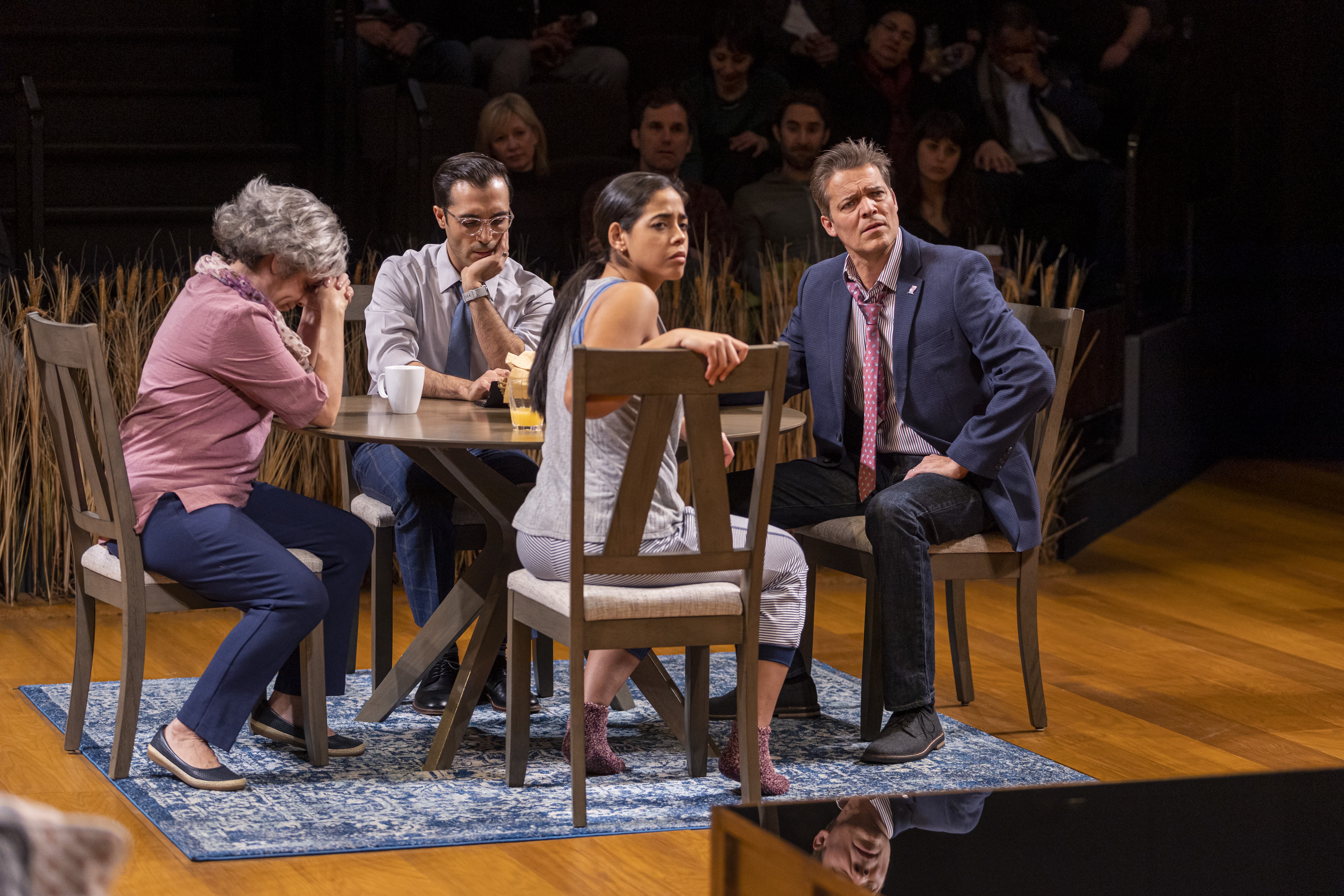 A group of people sit at a dinner table onstage in twenty50