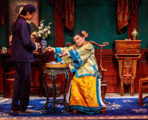 Afong Moy reaches for a bowl of rice held by Atung