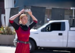 An actor places a crown on her head during a performance of Macbeth