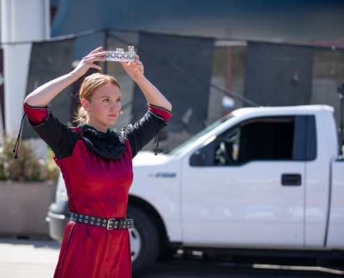 An actor places a crown on her head during a performance of Macbeth