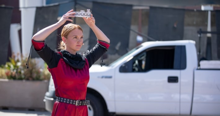 An actor places a crown on her head during a performance of Macbeth