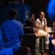 A person sits in front of an audience
