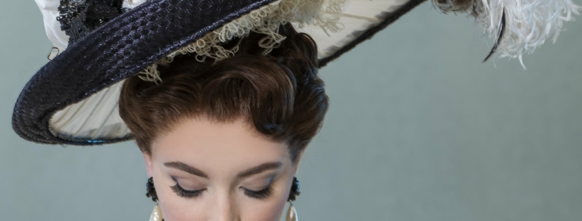 A woman in elegant dress with a large feathered hat