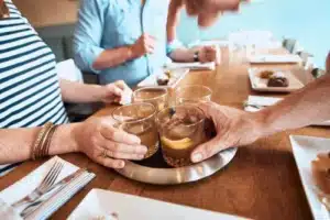 Hands reach for cocktails in the center of a table