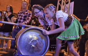 Two children roll a keg for keg bowling