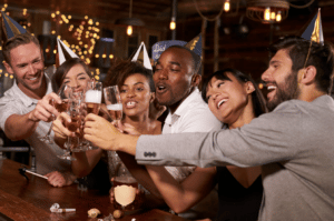 A large group of people celebrate by toasting their drinks