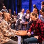 The cast of Come From Away sings together onstage