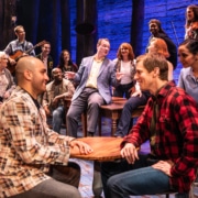 The cast of Come From Away sings together onstage