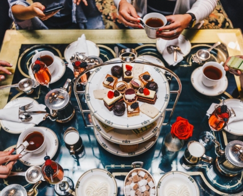 A dessert tower in the center of a table crowded with plates and treats