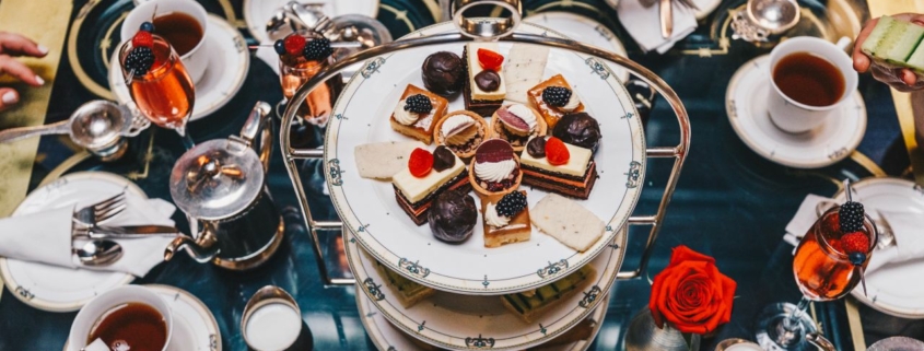 A dessert tower in the center of a table crowded with plates and treats