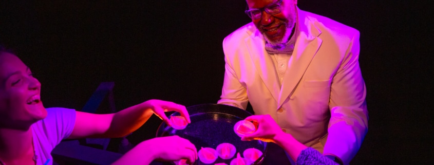 A person holds out a tray of snacks to several hands